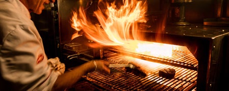 A chef grilling steaks