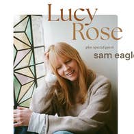 British songwriter Lucy Rose, a smiling woman leaning her head on one hand, looking downwards.