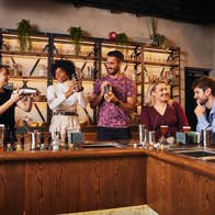 Four adults enjoying a whiskey cocktail making class at Roe & Co Distillery, Dublin.