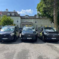 Three black coloured accessible people carrier taxis lined up in a row