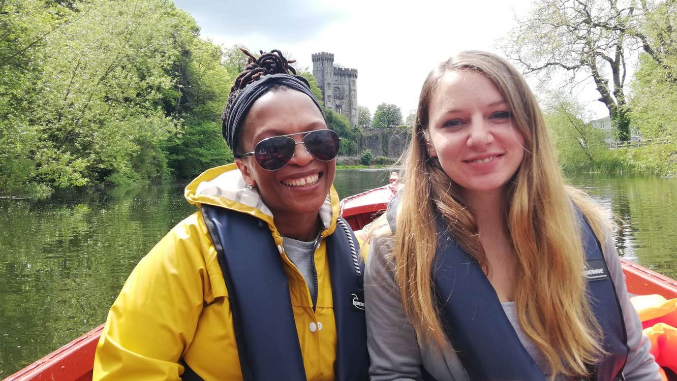 Two girls in a boat on River Nore with Kilkenny Castle in the background