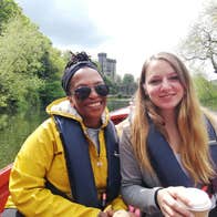 Two girls in a boat on River Nore with Kilkenny Castle in the background