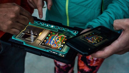 A close up of children solving a clue on a hand held device