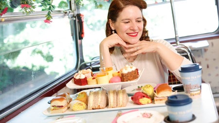 Passenger enjoying afternoon tea aboard a Vintage Tea Trips bus