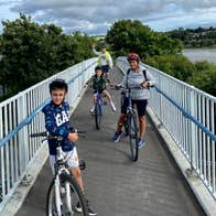 Family on a narrow bridge with their bikes