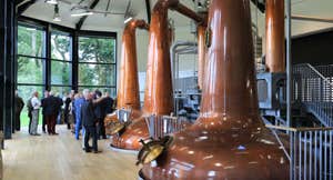 A group of people near copper stills at Royal Oak Distillery