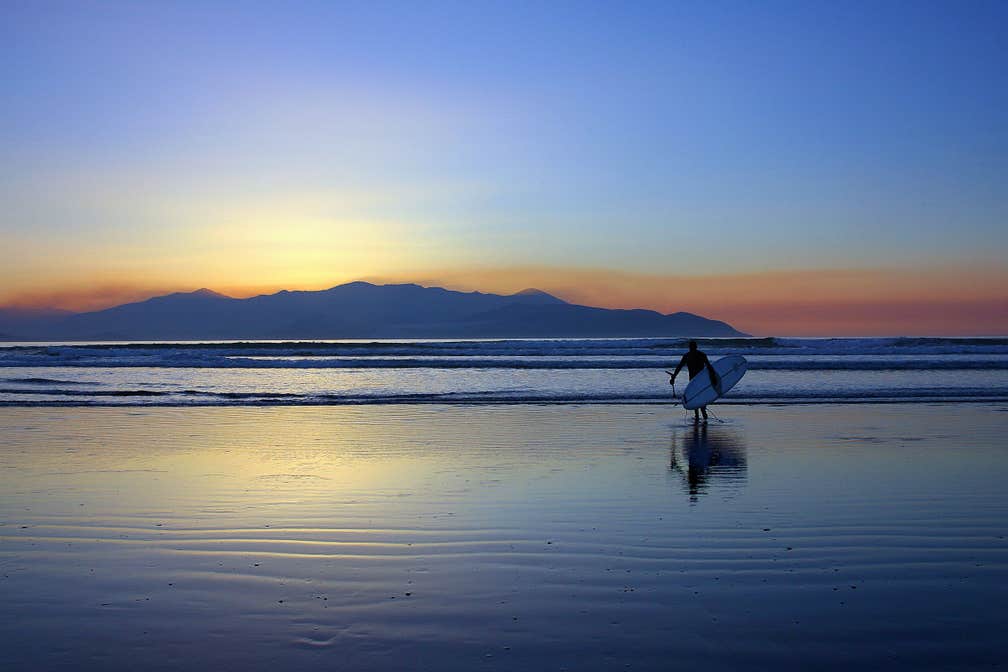 Image of a surfer at sunset on Castlegregory beach in County Kerry