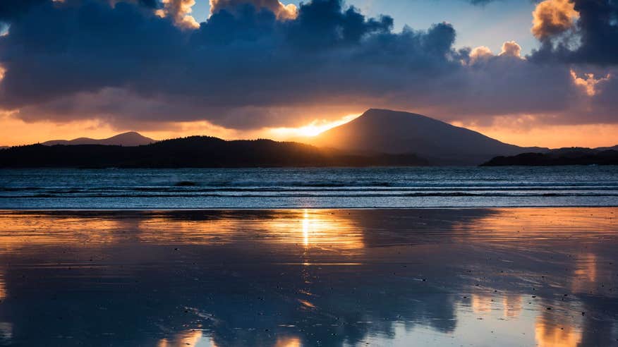 A stunning sunset behind mountains at Downings Beach.