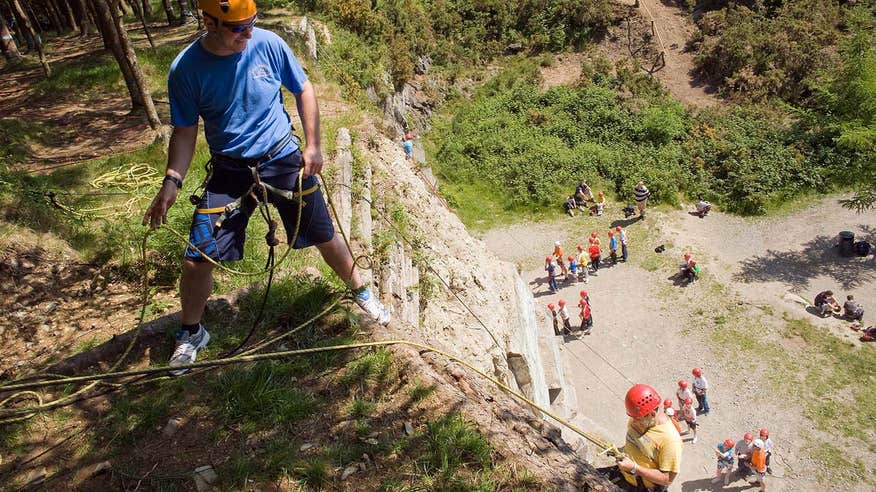 People abseiling down a vertical cliff in Carlingford in Louth