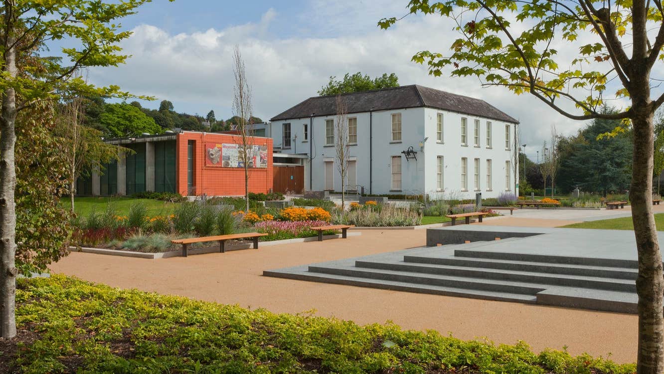 A Georgian style house set on grounds with lots of shrubs and trees