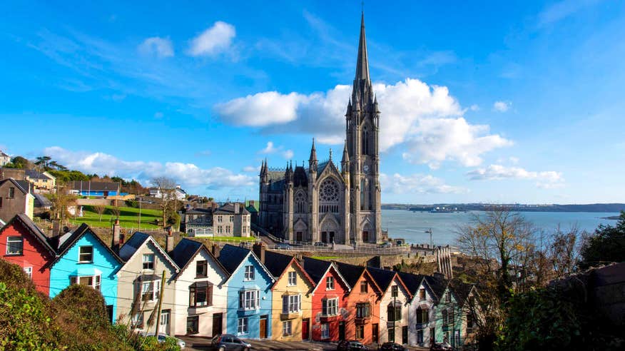 Colourful buildings in front of a church by the sea in Cobh, County Cork