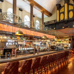 Long old fashioned bar with lots of ornate wood décor