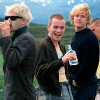 Four men drinking alcohol at the side of a road.