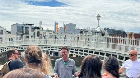 A guide with a group by the Ha Penny Bridge Dublin city