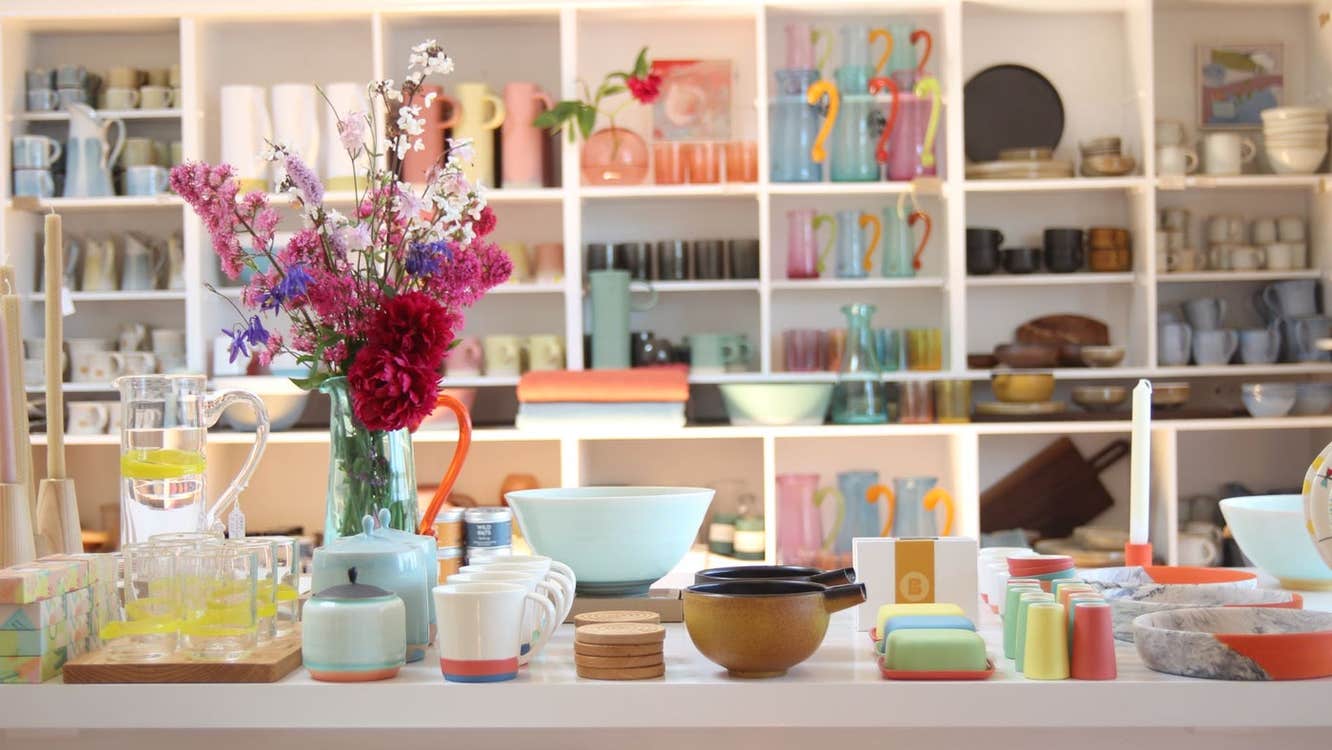 Counter and shelves in a shop full of colourful artisan ceramics