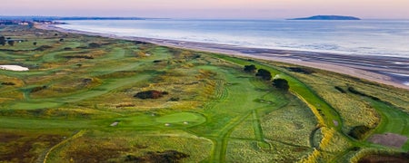 A view of a golf course with the sea in the background