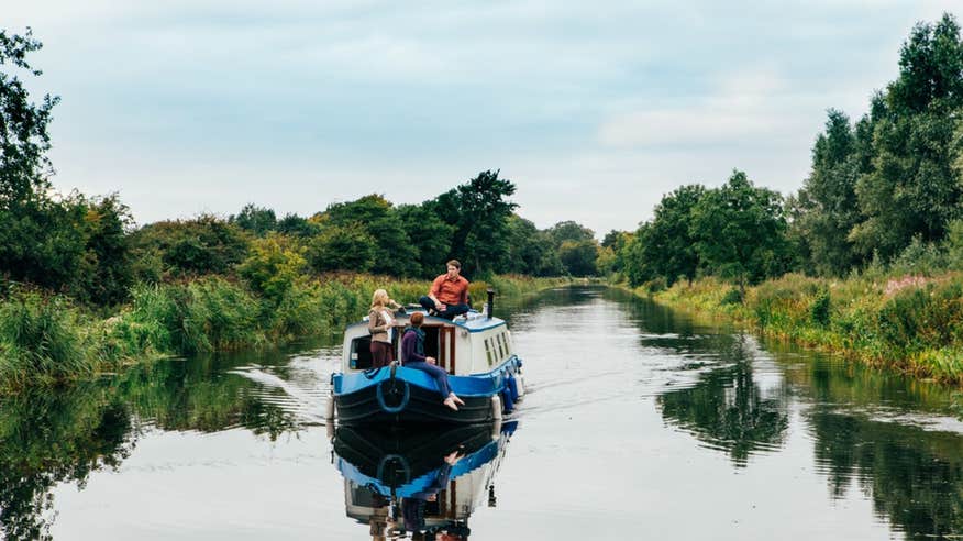 People sailing on a blue boat with Sallins Grand Canal barge trip in County Kildare