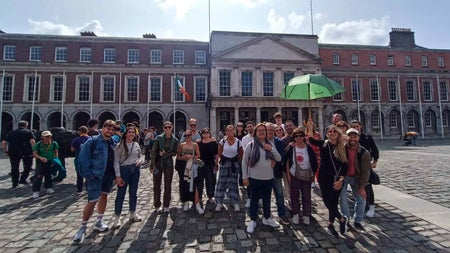 Group tour at Dublin Castle. One of the group is holding a green umbrella