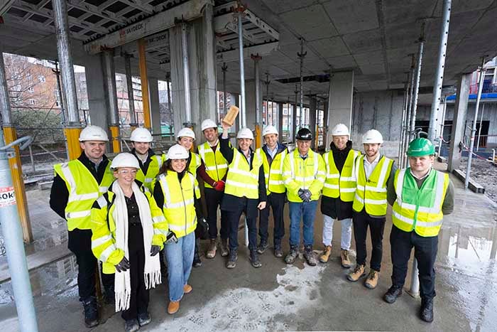 SNG and Greystar colleagues pose with brick on development site for Golden Brick ceremony