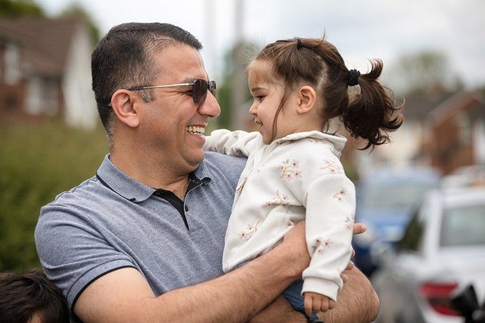 Father holding and smiling at his daughter