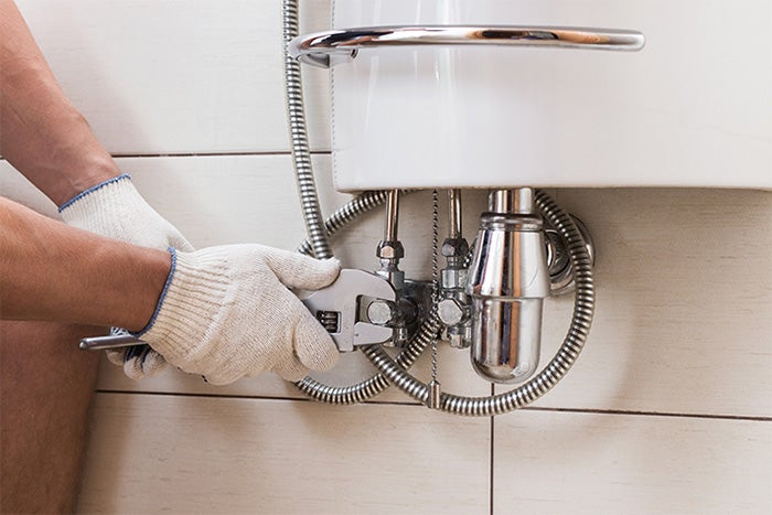 Repairs operative fixing a sink.