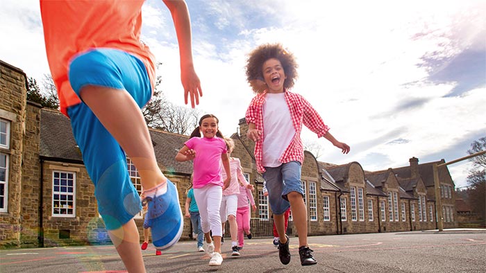 Children running in the street, having a whale of a time