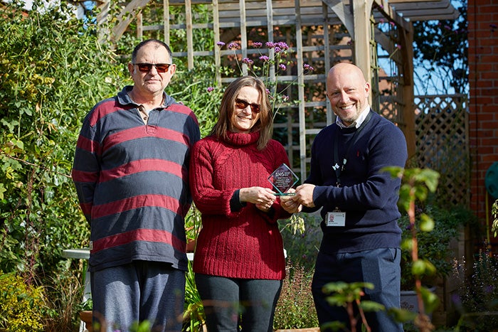 The winner of the sustainable garden competition for InBloom receiving her award, in her garden.