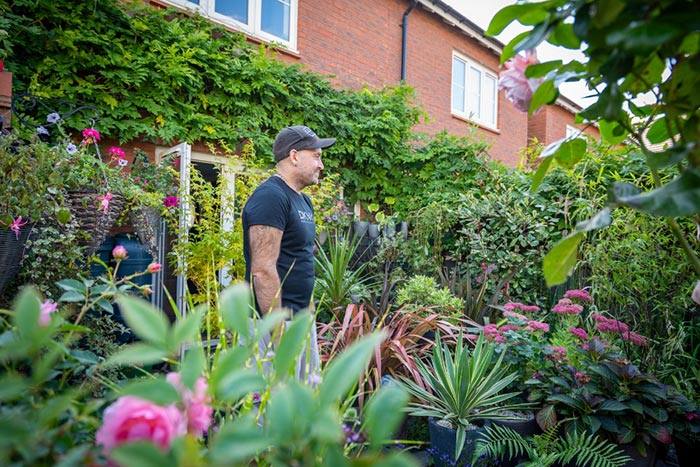 A man standing in a pretty garden