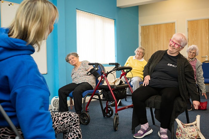 Image showing some elderly people doing exercise sitting down.