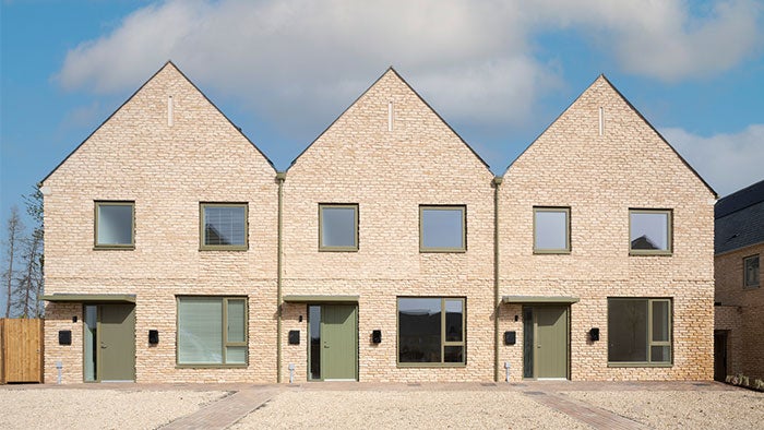 Three modern houses with sage green front doors